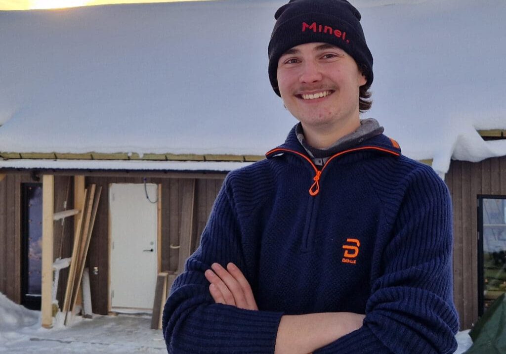 Bilde av en lærling som står utenfor et hus